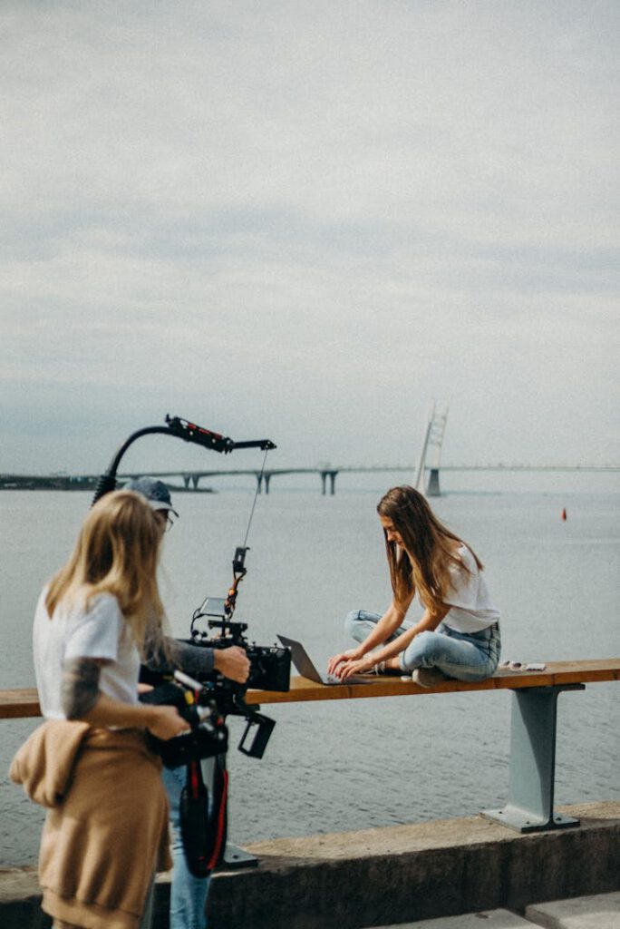 A filmmaker captures a woman working remotely by the sea.